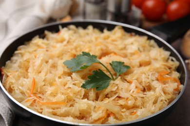 Photo of Frying pan with sauerkraut on table, closeup