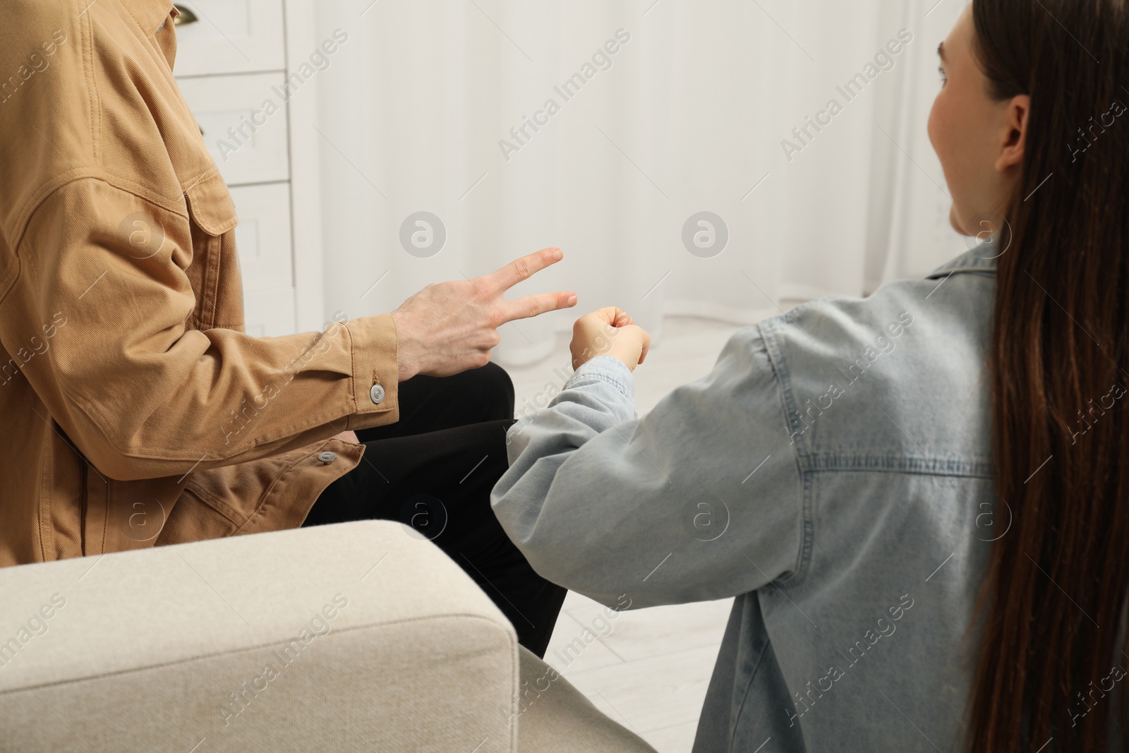 Photo of People playing rock, paper and scissors indoors, closeup