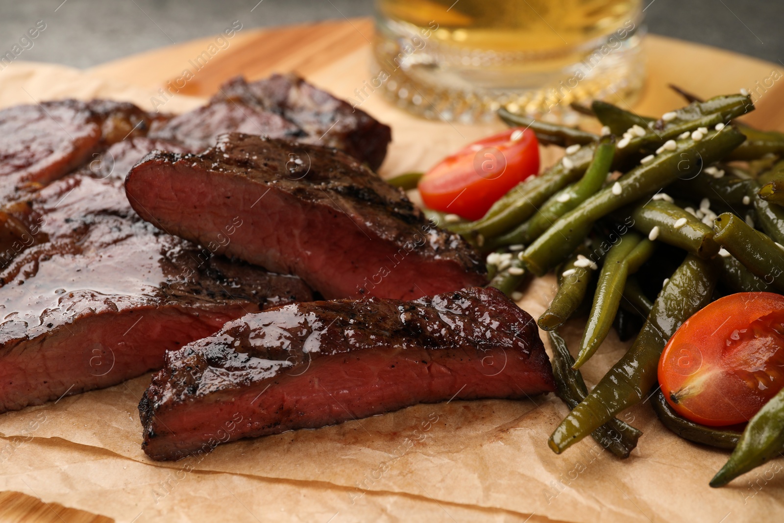 Photo of Delicious fried steak and asparagus on wooden table, closeup