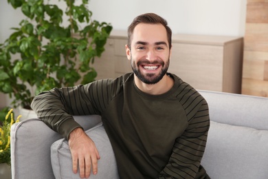 Portrait of young man laughing at home