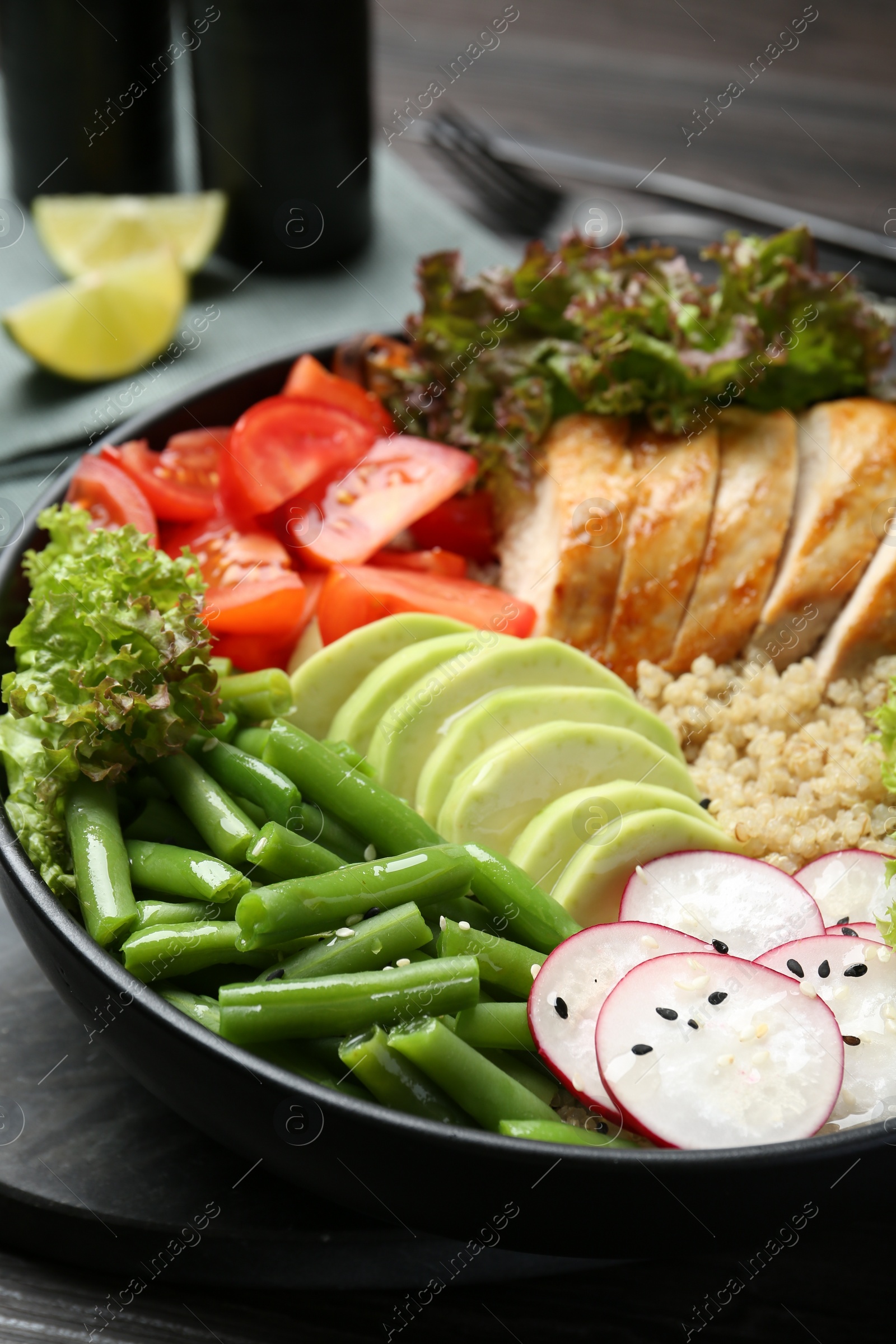 Photo of Healthy meal. Tasty products in bowl on black wooden table, closeup