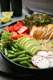 Photo of Healthy meal. Tasty products in bowl on black wooden table, closeup