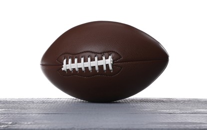 Photo of American football ball on grey wooden table against white background