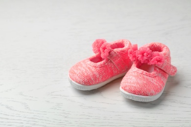 Photo of Pair of cute baby sandals on wooden background