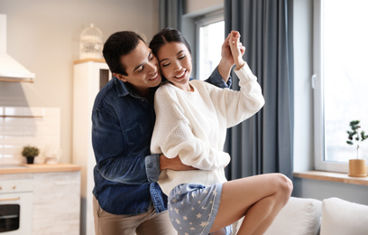 Photo of Lovely young interracial couple dancing at home