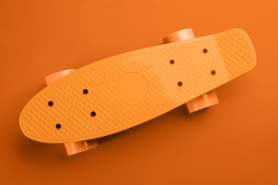 Image of Bright skateboard on orange background, top view
