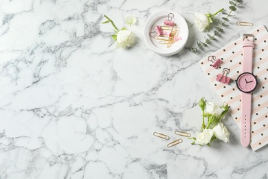 Photo of Flat lay composition with flowers, notebook and wristwatch on white marble background, space for text