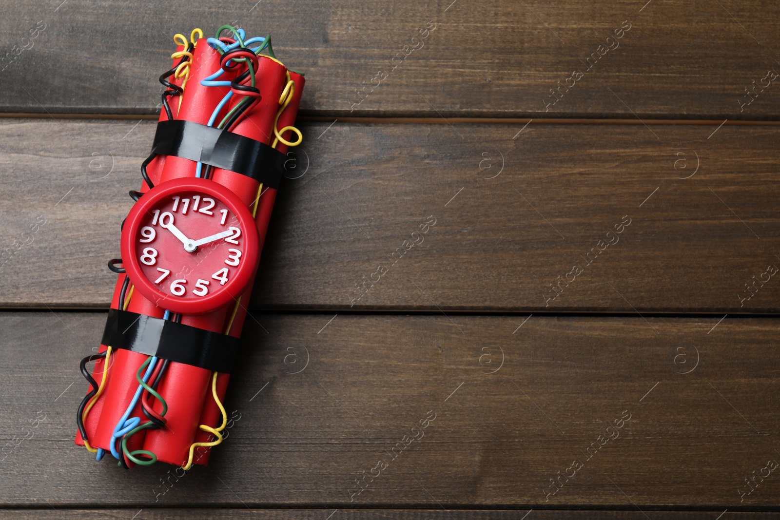 Photo of Dynamite time bomb on wooden table, top view. Space for text