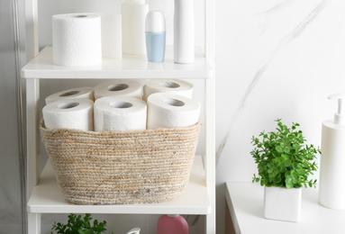 Toilet paper rolls on shelving unit in bathroom