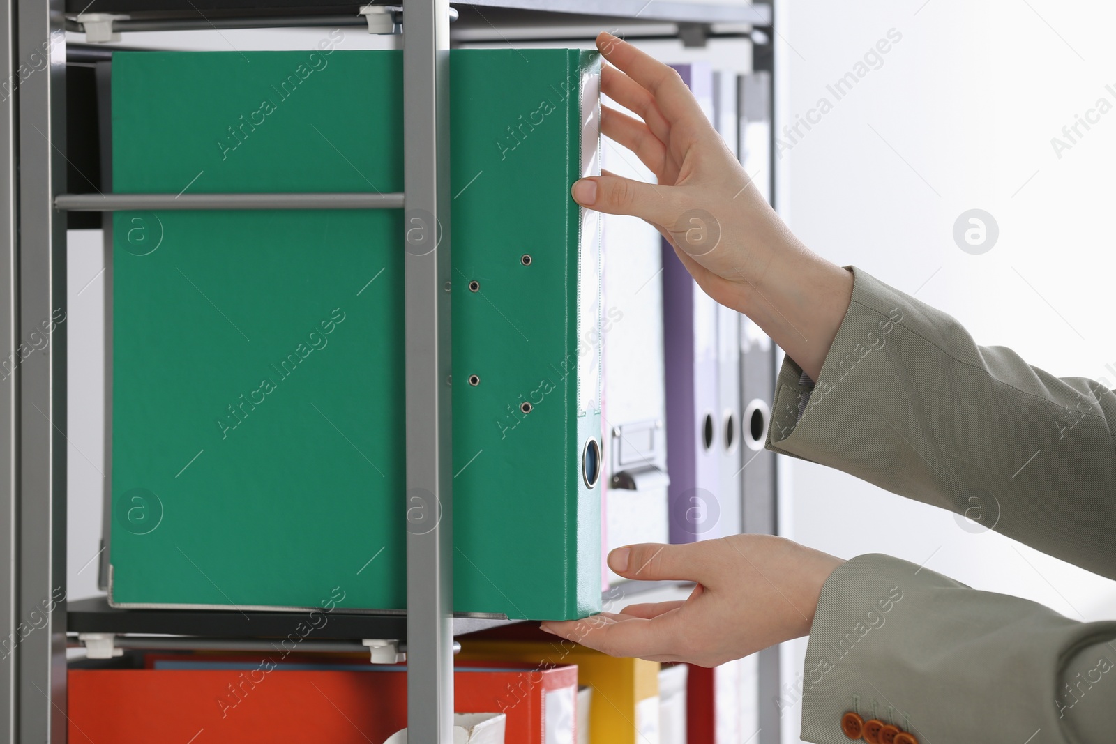 Photo of Woman taking folder with documents from shelf on white background, closeup