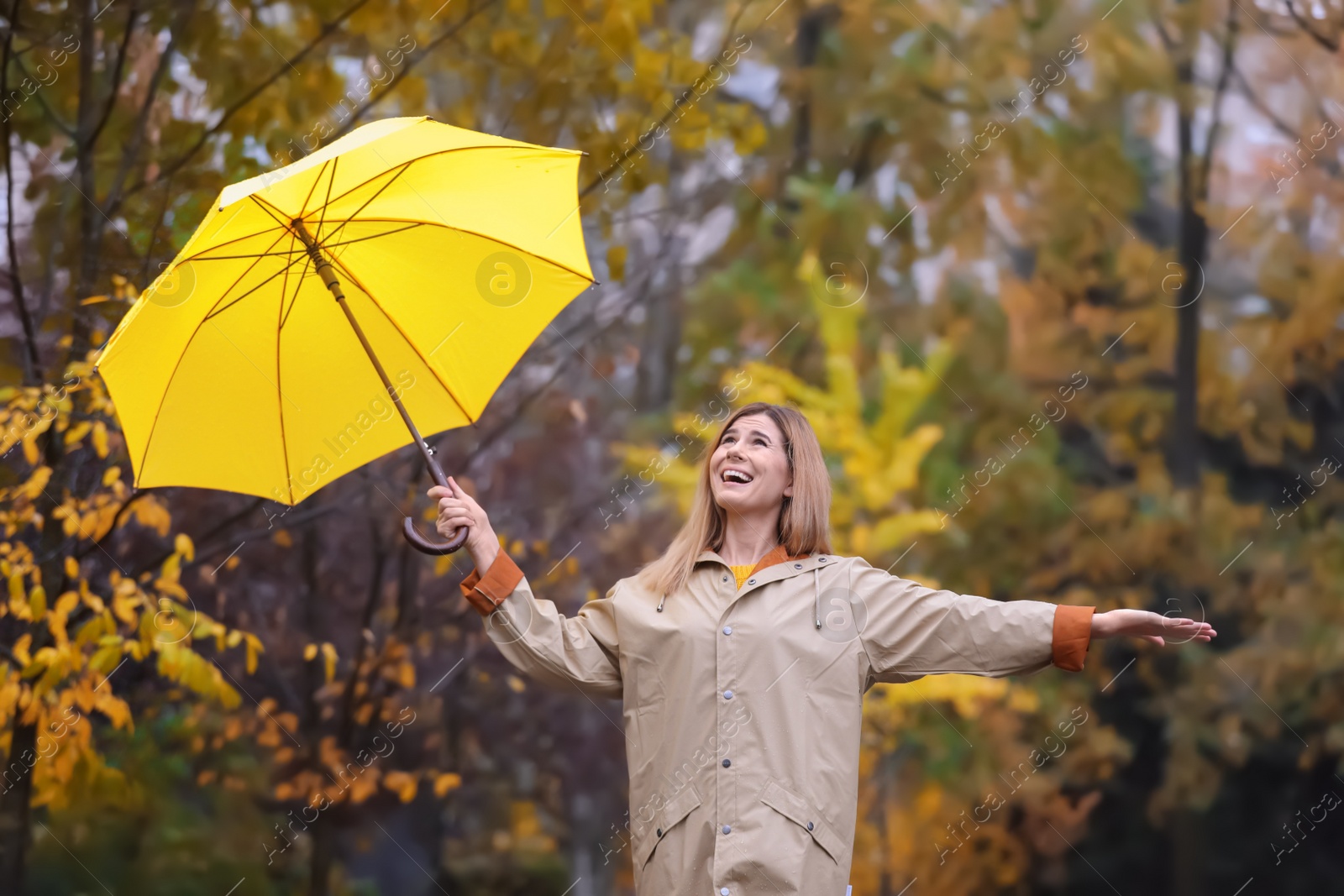 Photo of Woman with umbrella in autumn park on rainy day