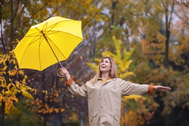 Photo of Woman with umbrella in autumn park on rainy day