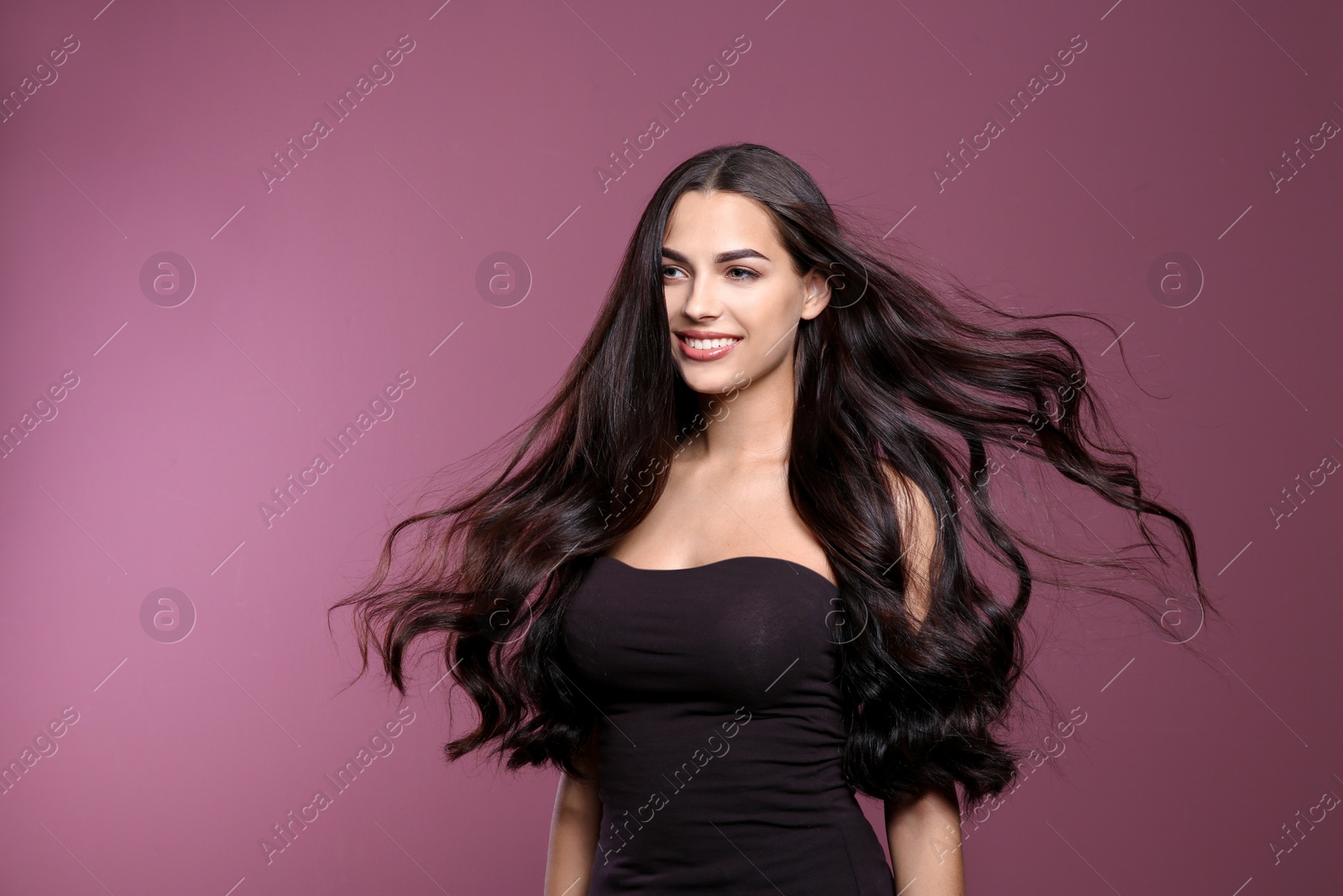 Photo of Portrait of beautiful model with gorgeous curly hair on color background