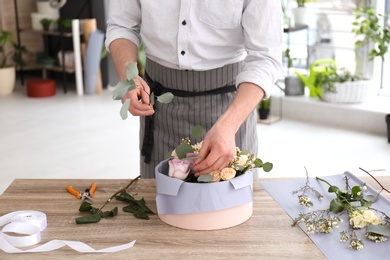 Male florist creating floral composition at workplace