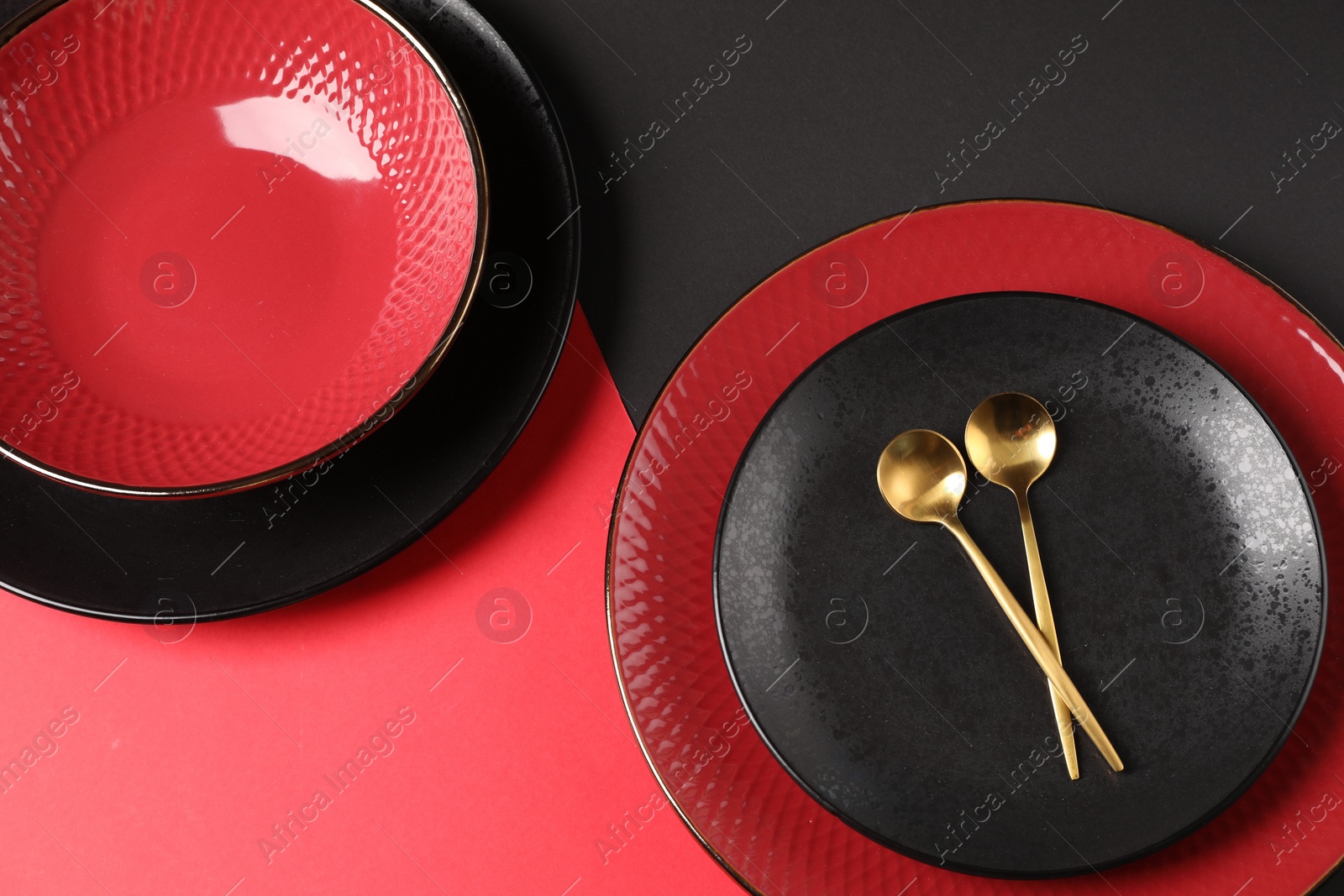 Photo of Stylish table setting with plates and spoons on color background, above view