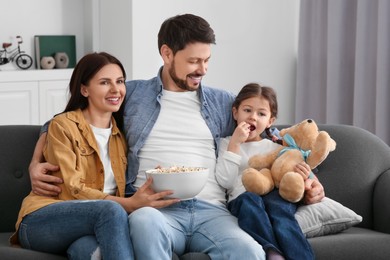Happy family spending time together while watching TV at home
