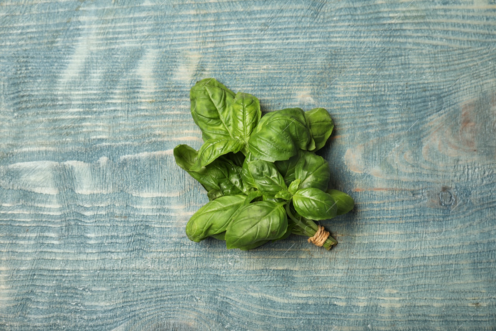 Photo of Fresh basil on wooden background, top view