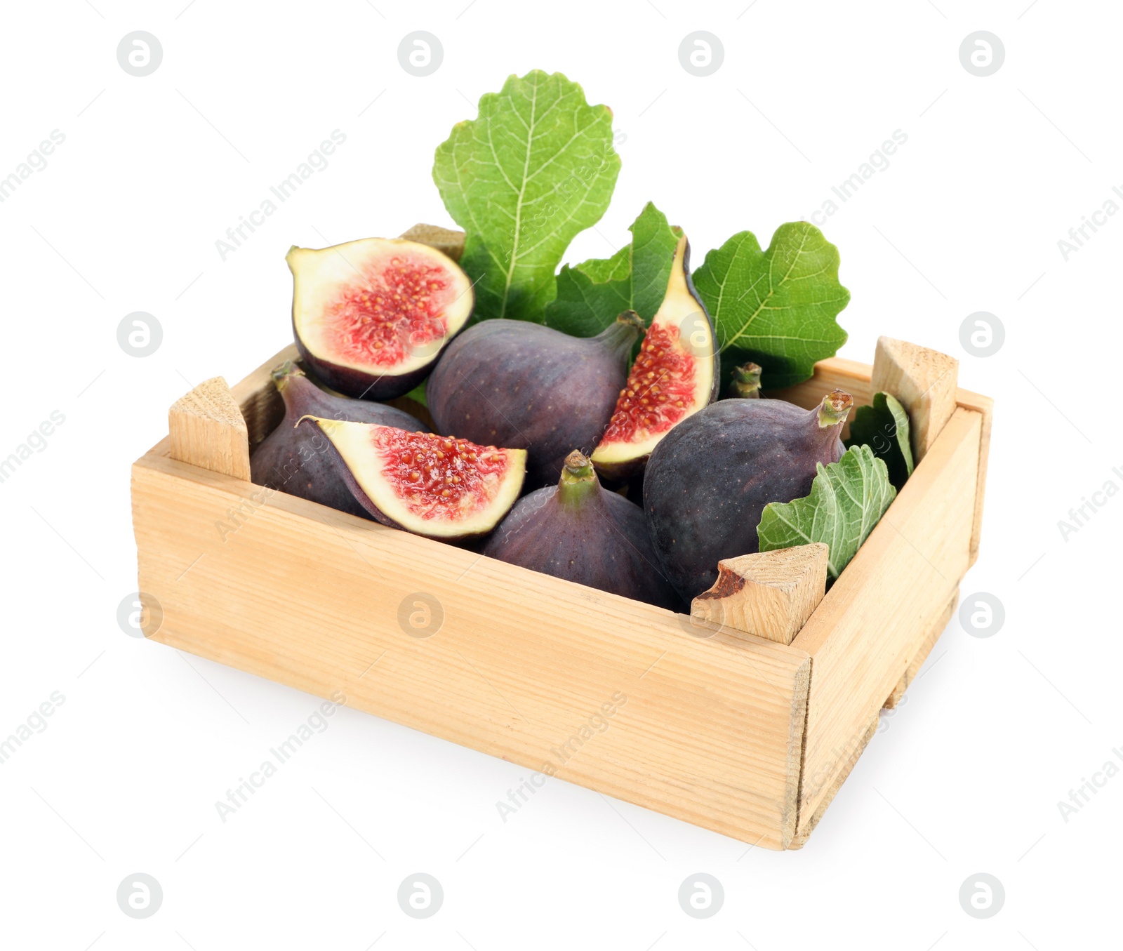 Photo of Whole and cut tasty fresh figs with green leaves in wooden crate on white background