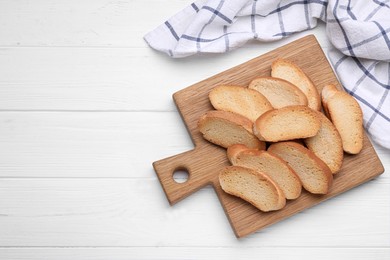 Photo of Tasty hard chuck crackers on white wooden table, top view. Space for text