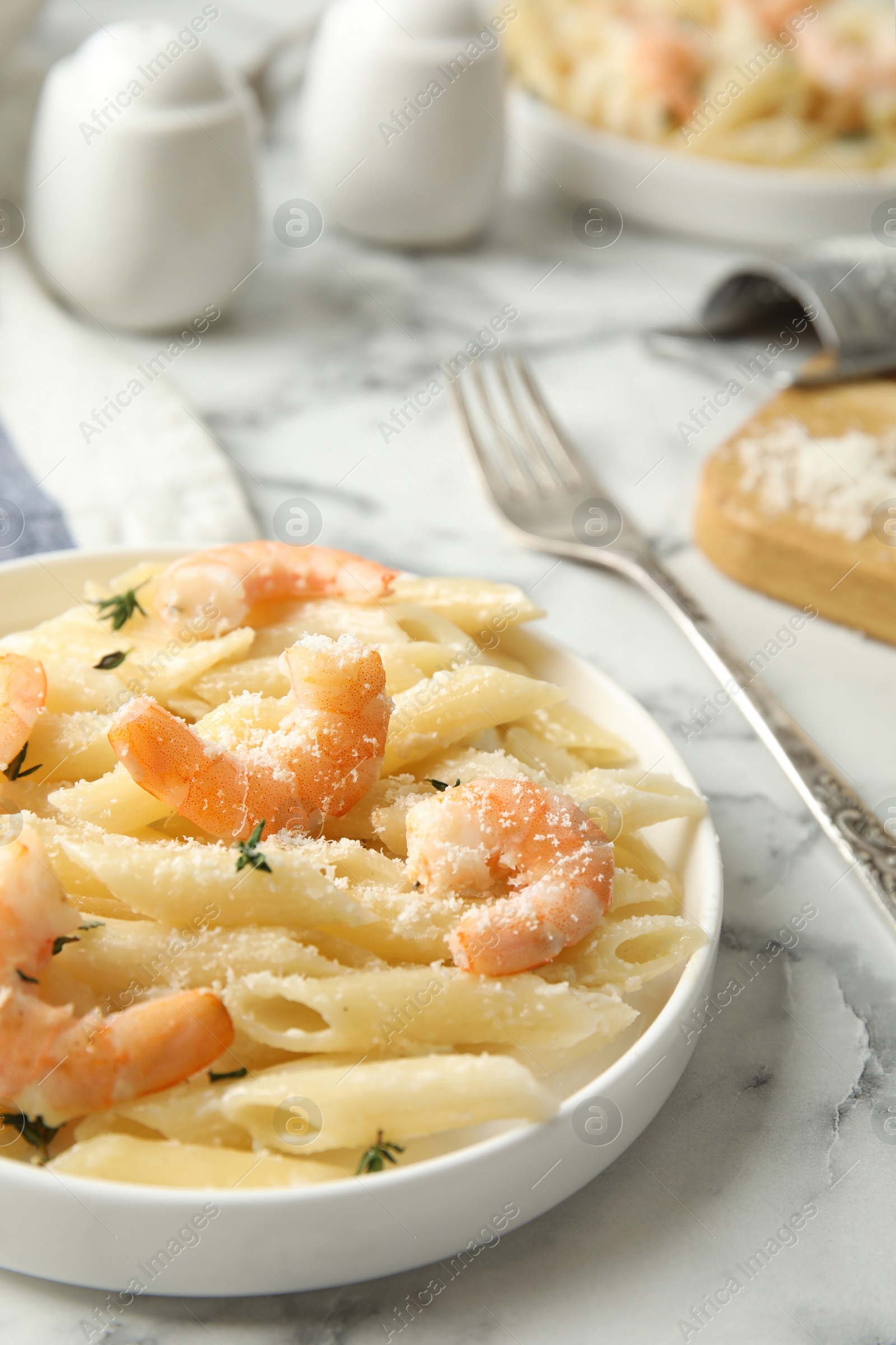 Photo of Delicious pasta with shrimps served on white marble table