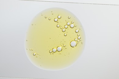 Photo of Sample of yellow facial gel on white background, top view