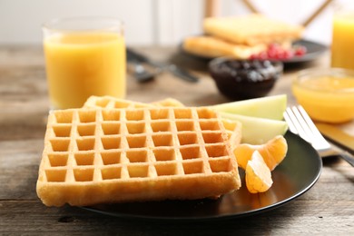 Photo of Waffles with fruits served on wooden table. Delicious breakfast