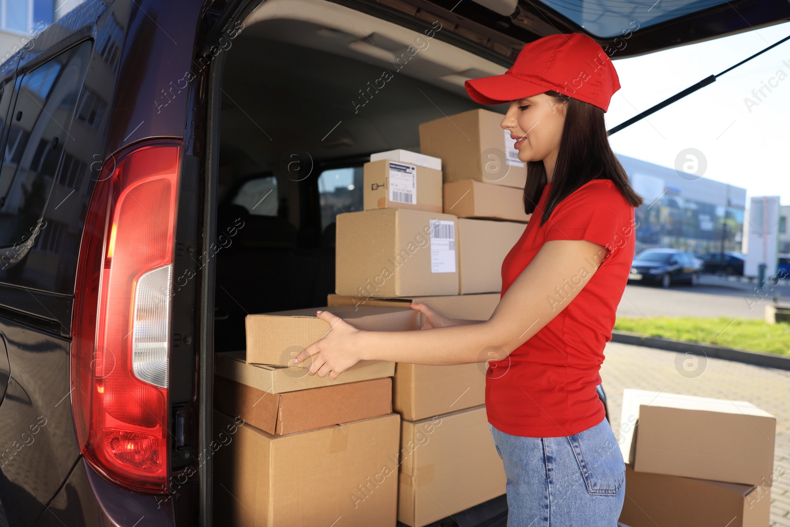 Photo of Courier taking parcel from delivery van outdoors