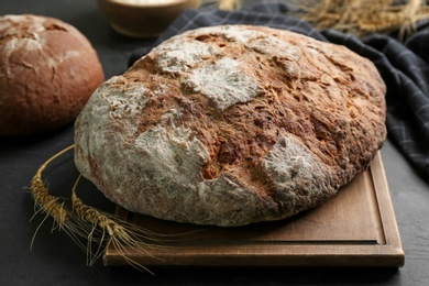 Photo of Freshly baked bread on black table, closeup