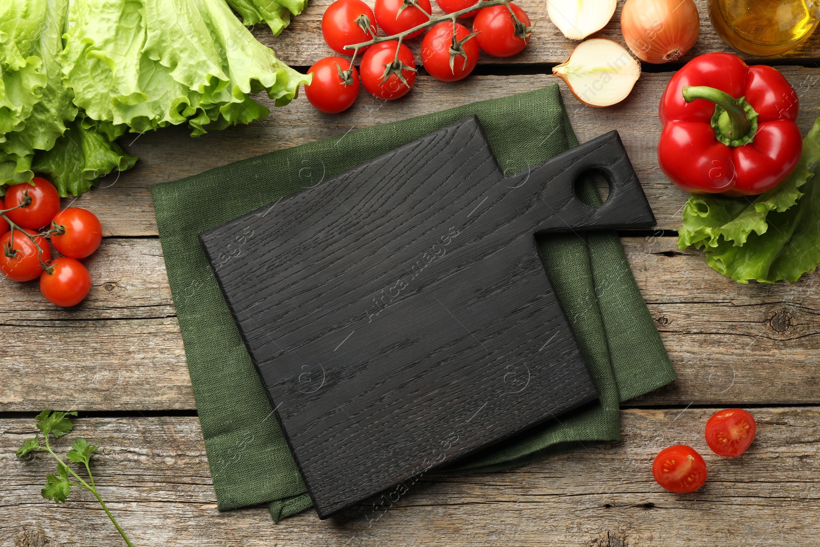 Photo of Flat lay composition with black cutting board and products on wooden table