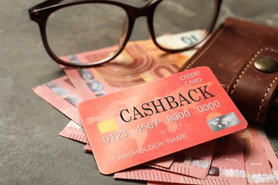 Cashback credit card, wallet, money and glasses on grey table, closeup