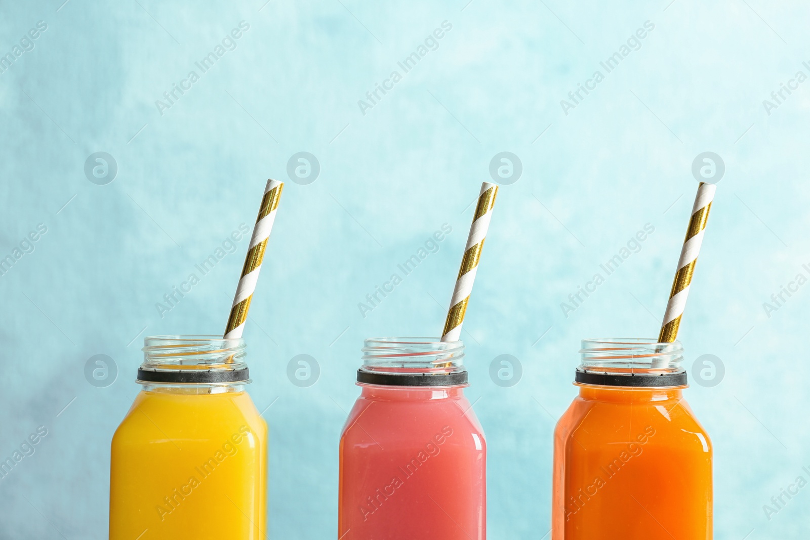 Photo of Bottles with tasty juices on color background