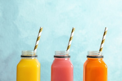 Bottles with tasty juices on color background