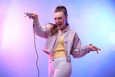 Photo of Emotional singer with microphone performing in color lights