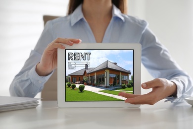 Woman showing rental property website on tablet computer, closeup