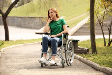 Young woman in wheelchair at park on sunny day