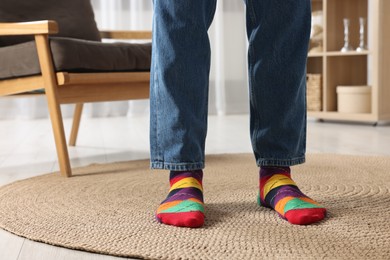 Photo of Man in stylish colorful socks and jeans indoors, closeup