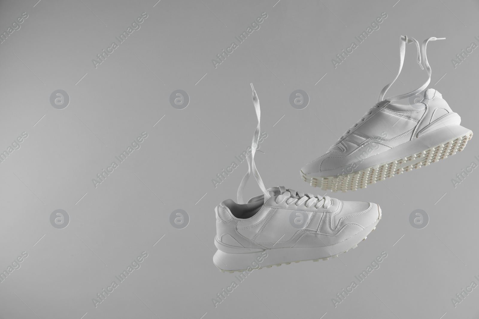 Photo of Pair of stylish white sneakers on light grey background. Space for text