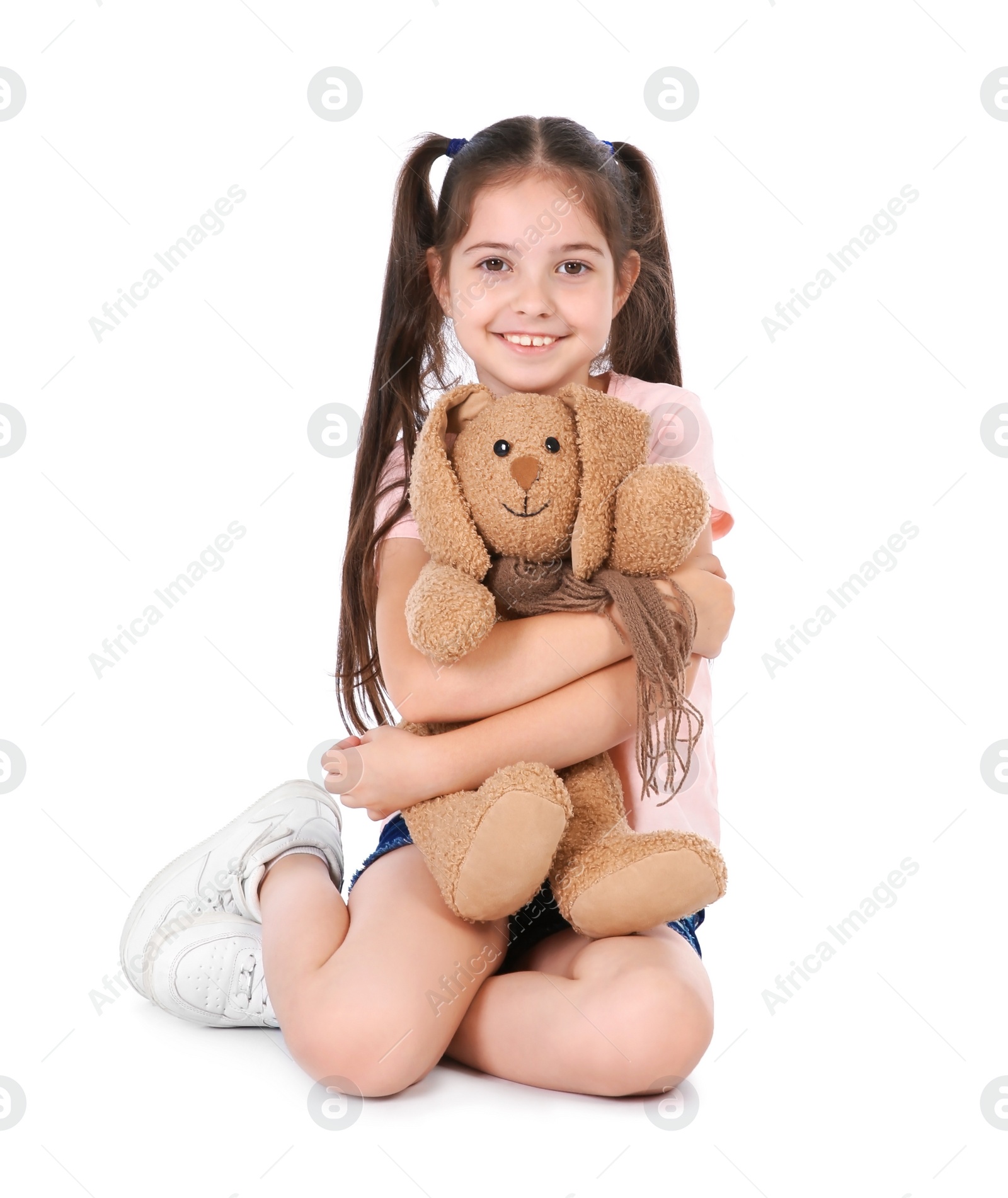 Photo of Playful little child with plush toy on white background. Indoor entertainment