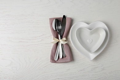 Beautiful table setting on white wooden background, flat lay. Space for text