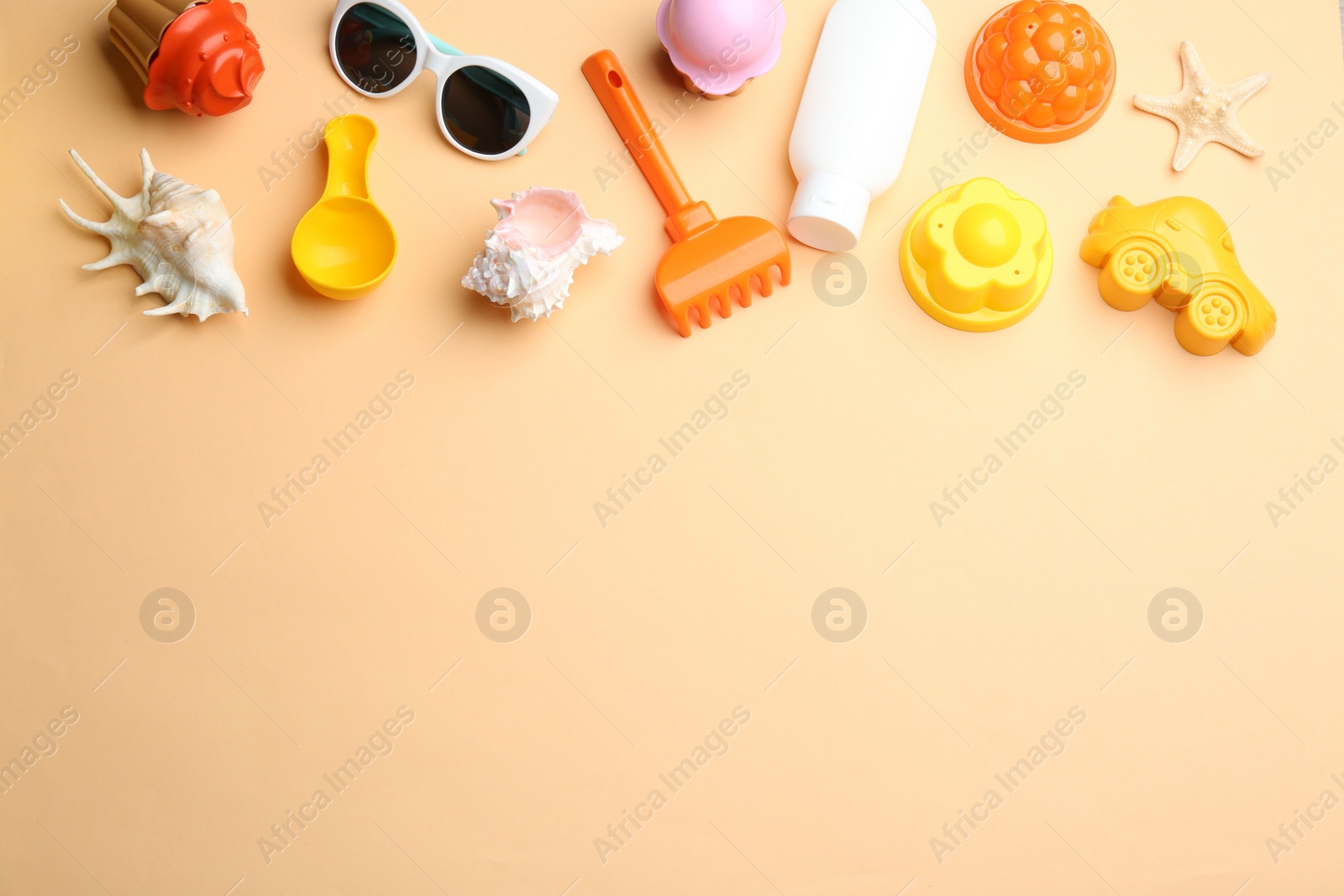 Photo of Flat lay composition with bright beach toys on color background. Space for text