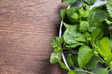 Fresh lemon balm on wooden table, top view. Space for text