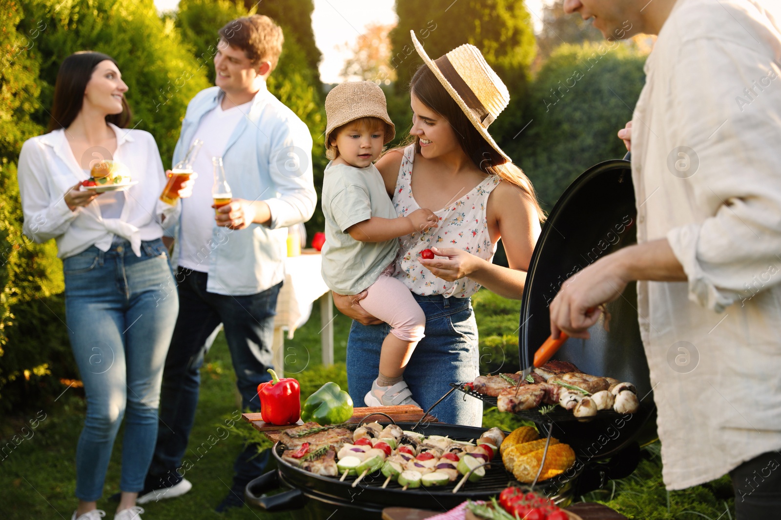 Photo of Family with friends having barbecue party outdoors