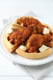 Delicious Belgium waffles served with fried chicken and butter on white table, closeup