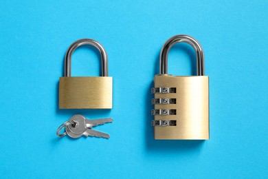 Different padlocks and keys on light blue background, top view