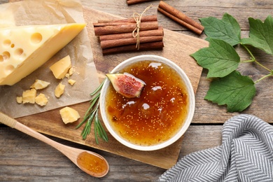 Photo of Flat lay composition with delicious fig jam on wooden table