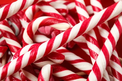 Photo of Sweet candy canes as background, closeup view