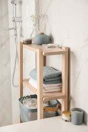 Shelving unit with clean towels in bathroom interior