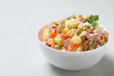 Photo of Bowl of traditional salad Olivier on light table