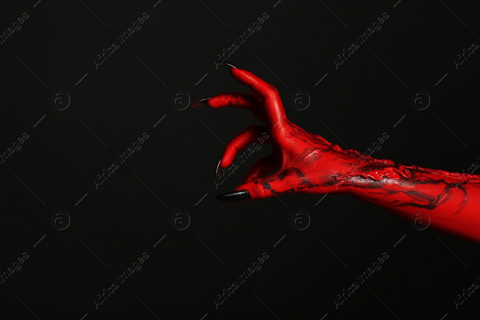 Photo of Scary monster on black background, closeup of hand with space for text. Halloween character