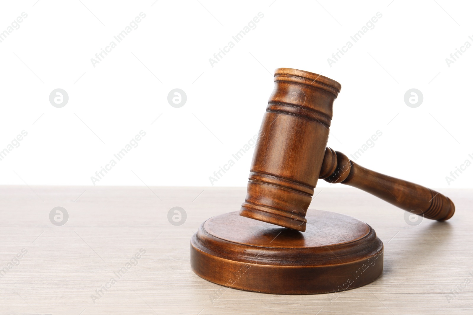 Photo of Wooden gavel on light table against white background. Space for text